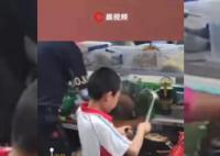 男孩在学校门口帮父亲摆摊炒面 动作熟练手法到位