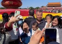 游客天安门广场花篮前拍下全家福 十一当天打卡天安门广场