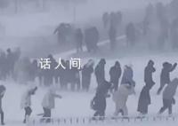 哈尔滨学生在暴风雪中艰难行走 街道路面犹如溜冰场
