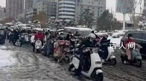河南市民骑电动车在雪地里艰难前行 走路上班的步履艰难