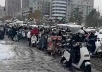 河南市民骑电动车在雪地里艰难前行 走路上班的步履艰难